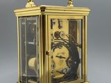 an image of a gold clock with a glass case on a stand