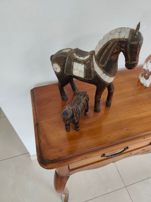 une petite table en bois sur laquelle se trouvent un cheval et un chien