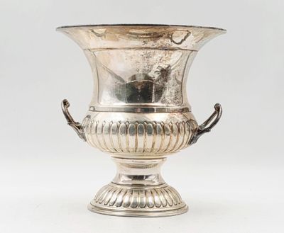 un vase ancien en métal argenté muni d'anses, sur fond blanc