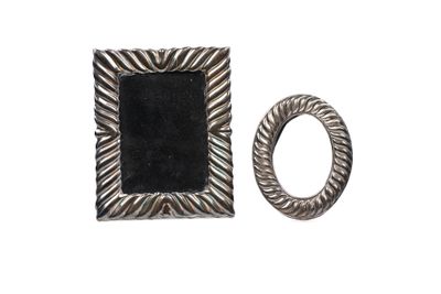 un gros plan d'une bague et d'un cadre photo sur fond blanc