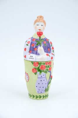 ceramic figurine of a woman with flowers in a vase
