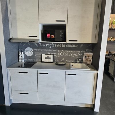 a kitchen with a microwave, oven, cabinets, and pictures on the wall