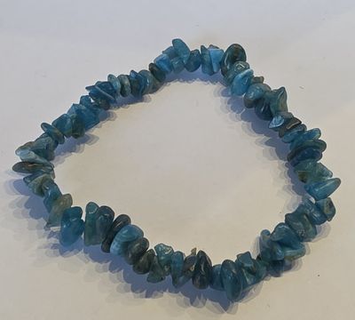 un gros plan d'un bracelet orné de perles bleues sur un fond blanc