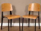 deux chaises en bois assises l'une à côté de l'autre sur un sol en bois dur