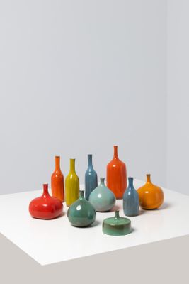 many different colored vases sitting on a white table