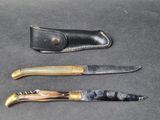 three different types of knives on a black surface with a leather sheath