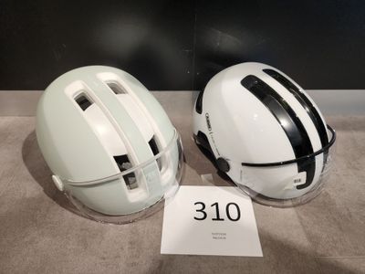 une paire de casques blancs ornés de bandes noires et de numéros