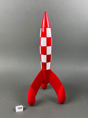 a close up of a red and white toy rocket on a gray surface