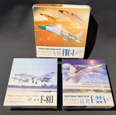 trois livres dans leur boîte, posés sur une table, avec une photo d'avion en arrière-plan