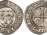 a silver coin with a cross on the front and a shield on the back