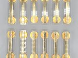 six clear tubes with gold coins in them sitting on a white surface