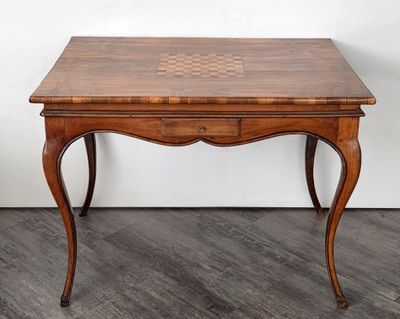 une petite table en bois sur laquelle est posé un échiquier