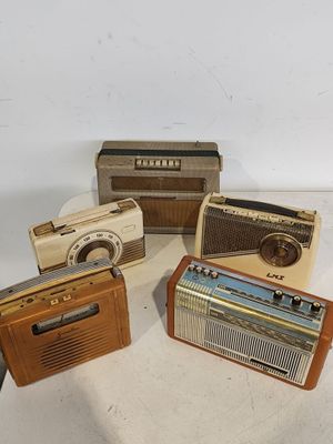 Plusieurs radios à l'ancienne sont posées sur une surface blanche