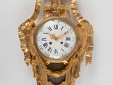 une horloge en or ornée de chiffres romains et d'une couronne