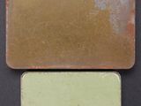 a close up of two different colored tiles on a black surface