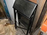 a black stool sitting next to a stack of boxes