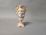a vase that is sitting on a stand on a table