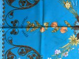 a close up of a blue table cloth with flowers on it