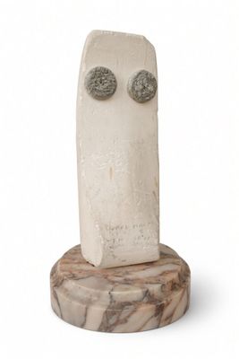 sculpture of a face on a marble base with two eyes