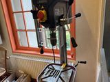 a drill on a stand in front of a window