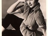 black and white photograph of a woman sitting on a bed