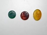 trois oursons en gélatine de couleurs différentes, assis les uns à côté des autres sur une surface blanche