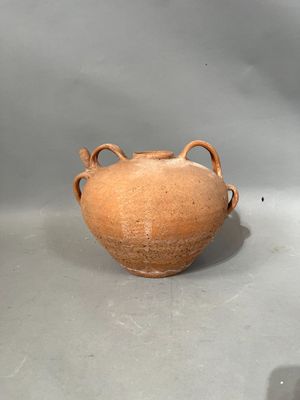 un vase brun posé sur une table à fond gris