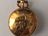 a gold pocket watch with a picture of a woman on it