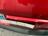 a sticker on the bumper of a red car that has a sticker on it