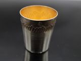 a silver cup that is sitting on a black table