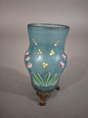 un vase bleu avec des fleurs posé sur une table