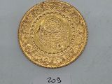 a close up of a gold coin on a white surface