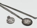deux bijoux en argent posés sur une surface blanche
