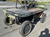 un petit camion vert à plateau garé sur un parking