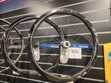 trois vélos exposés dans un magasin, avec une étiquette de prix accrochée au mur