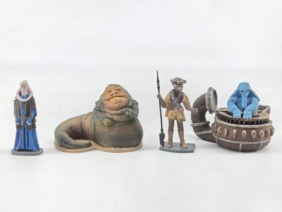 cinq figurines représentant des personnages de Star Wars posées sur une surface blanche