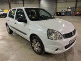 La petite voiture blanche est garée dans un grand garage.