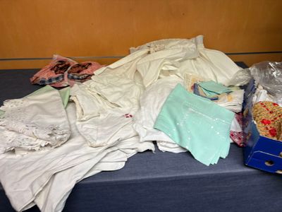 un tas de vêtements posé sur une table à côté d'une boîte bleue