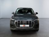 the front view of a dark colored audi suv parked in a white room