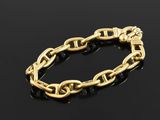 a gold chain bracelet on a black surface