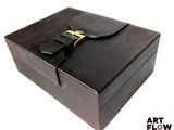 une boîte en cuir noir ornée d'une boucle dorée