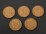 four gold sovereigns on a black surface
