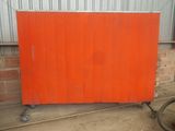 un gros plan sur un panneau orange monté sur roulettes devant un immeuble