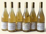 six bouteilles de vin sont alignées sur une surface blanche