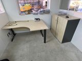 a desk with a computer on it in a small room
