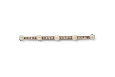 un gros plan sur une broche en forme de barre, ornée de perles et de diamants