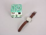 a watch sitting next to a box with a watch on it