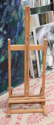 a wooden easel sitting in front of a painting display
