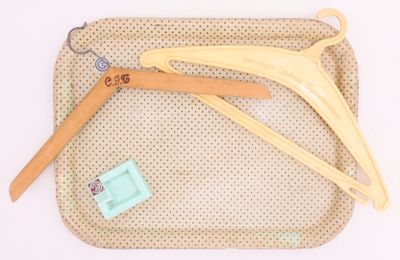 trois cintres en bois posés sur un sac beige