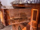 a close up of a wooden dresser with a marble top